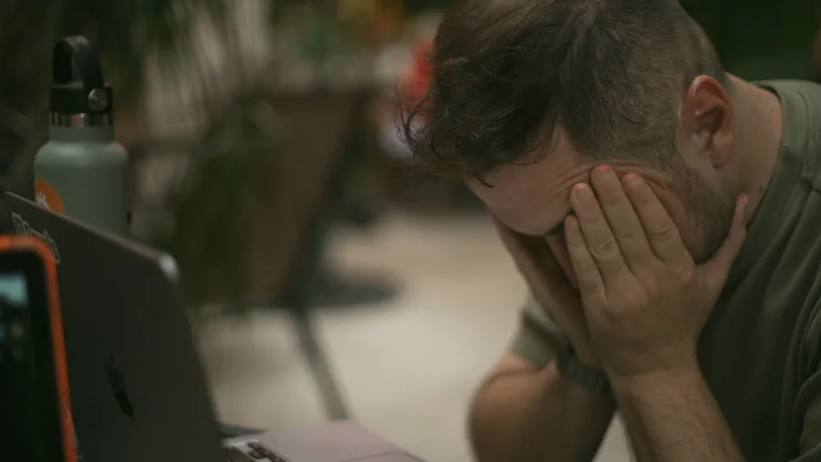 A person pausing at a desk during a long day